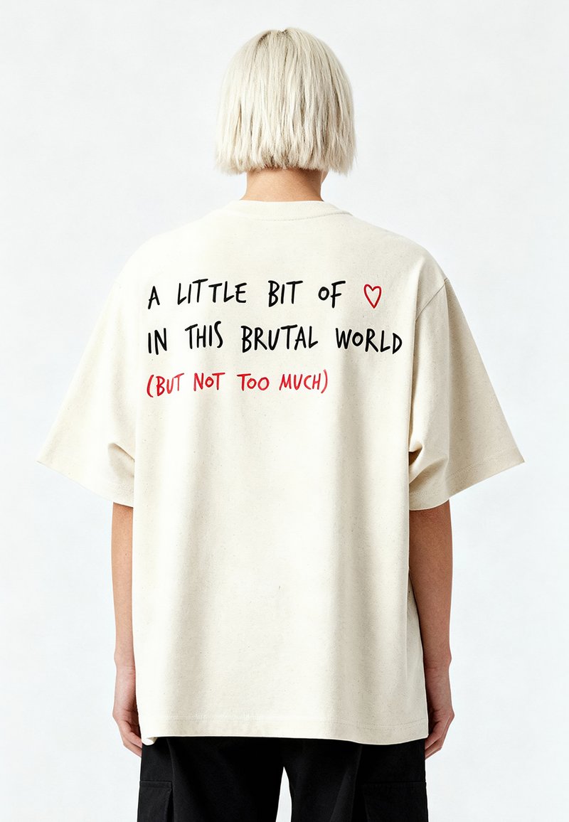 Beidzot kokvilnas T-krekls, kas raksturīgs ar pārāk lielu piegriezumu, īsām piedurknēm un tekstu aizmugurē: "Mazliet ❤️ šajā brutālajā pasaulē (BET NE PAR DAUDZ)."
