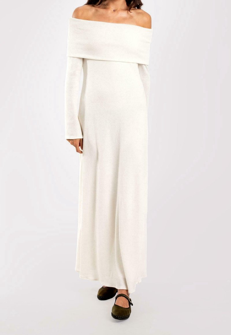 Robe en tricot crème à manches longues, décolletée sur les épaules, avec une silhouette droite, présentant une texture lisse et un design longueur sol.