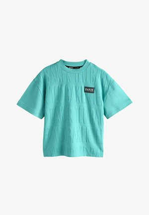Türkisfarbenes T-Shirt mit kurzen Ärmeln und erhabenem, wiederholtem Schriftzug "BAKER" sowie einem kleinen schwarzen Markenlabel auf der Vorderseite. Aus Baumwollmaterial.