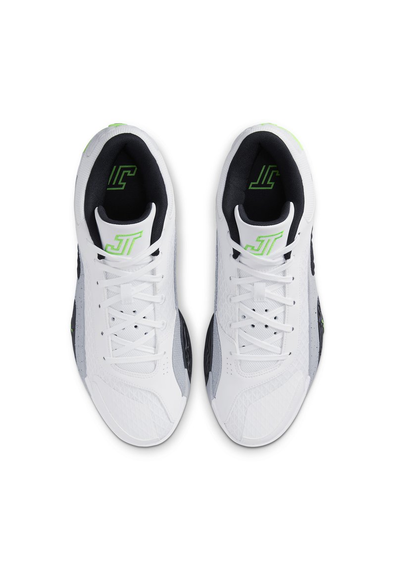 Zapatillas deportivas blancas con acentos negros y grises. Parte superior texturizada, cierre de cordones, patrones circulares en los laterales y detalles del logo en verde.