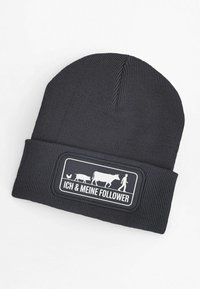 Dark gray knit beanie with a ribbed texture. Features a rectangular patch with white graphic illustrations of animals and the text "ICH & MEINE FOLLOWER."