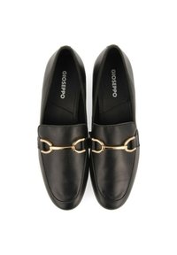 Mocassins en cuir noir avec un accent de chaîne en ton doré sur le devant, présentant une texture lisse et un design à bout rond.