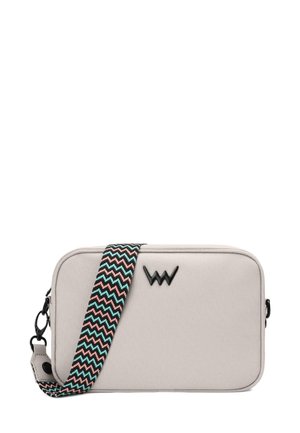 Beige rectangular bag with a textured fabric, black zipper, and a woven strap featuring a zigzag pattern in teal, black, and beige tones.
