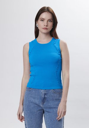 Blauwe geribbelde tanktop met kantdetails aan de zijkanten, met een nauwsluitend ontwerp en een ronde halslijn, gecombineerd met lichte denim jeans.