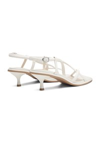 Sandales à talons blancs à lanières avec un talon conique bas et une finition en cuir lisse. Présente une fermeture à boucle et un design minimaliste.