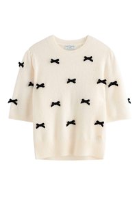 Maglione crema con maniche corte, tessuto testurizzato e fiocchi in velluto nero distribuiti uniformemente sulla parte anteriore. Orlo e scollo a coste.