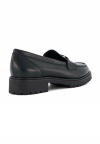 Black leather loafers with a low, chunky sole and ridged texture. Features a sleek design and minimalistic detailing on the vamp.