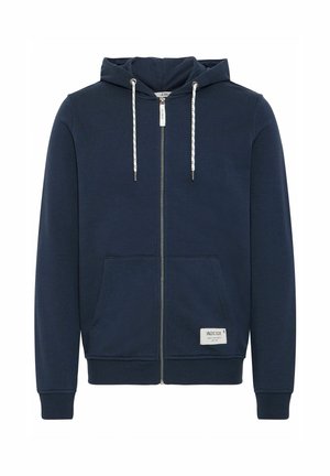 Sudadera con cremallera color azul marino, hecha de tela suave, que presenta una capucha con cordón, dos bolsillos frontales y un parche con logo cerca del dobladillo.