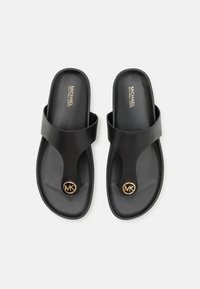 Chanclas negras de color negro con textura suave, tira ancha y logo dorado circular de MK en la plantilla. Diseñadas para un uso fácil.