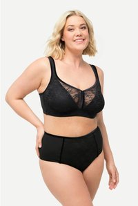 Soutien-gorge en dentelle noire avec des panneaux transparents et des larges bretelles, associé à des culottes taille haute noires présentant une texture lisse et une couverture modérée.