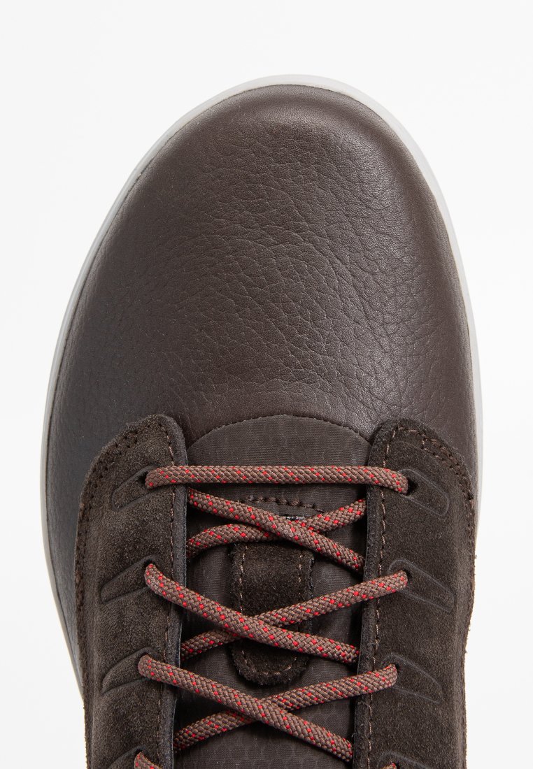 Braune Leder-Sneaker mit runder Zehenpartie, strukturiertem Finish, hellfarbiger Sohle und rot akzentuierten Schnürsenkeln. Verfügt über ein seitliches Suede-Panel.