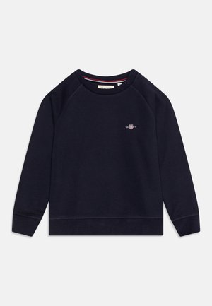 Sweatshirt bleu marine avec un col rond, des manches raglan et des poignets côtelés. Présente un petit logo sur la poitrine et une texture douce.