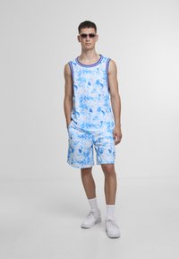 Blå og hvit topp og matchende shorts med marmoraktig mønster, laget av lett stoff. Har rund hals og sidelommer.