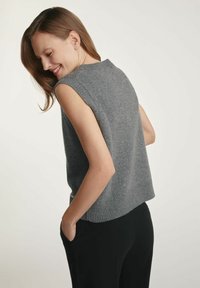 Szary bezrękawnik z miękkiego dzianiny z prążkowanym dołem. Lekko luźny fason z okrągłym dekoltem i bez dodatkowych akcentów lub wzorów.