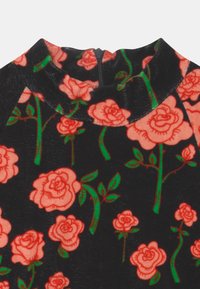 Tela negra con patrón floral rojo y tallos verdes, con un cuello alto y una cremallera en la parte posterior.