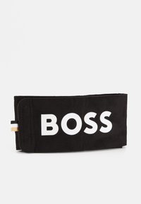 Schwarzes Wildleder-Portemonnaie mit einem auffälligen weißen "BOSS"-Logo. Das Design ist rechteckig mit einer strukturierten Oberfläche und einer farbigen Seitenakzent.