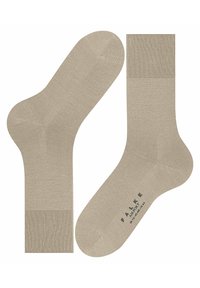 Calzini alla caviglia beige con polsini a coste, texture liscia e punta rinforzata. Presentano il logo del marchio stampato in colore scuro sulla suola.