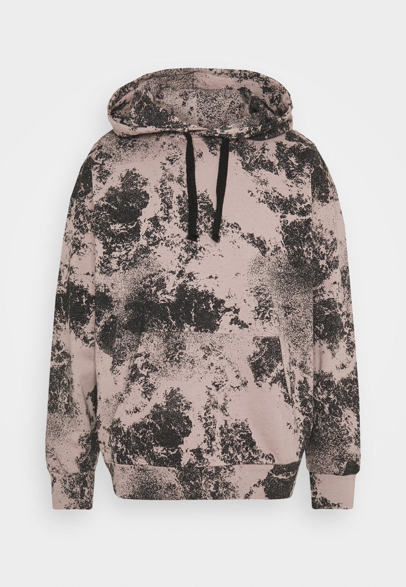Sweat à capuche rose clair avec un motif abstrait en éclaboussures noires, poche frontale et cordons noirs sur la capuche.