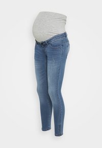 Jeans de maternidad en denim azul medio con una banda elástica gris en la barriga, diseño ajustado y sutiles detalles de desgate en la parte delantera.