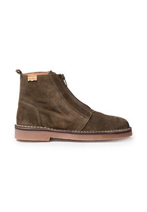 Brown suede ankle boots with an asymmetrical zipper, stitched detailing, and a tan rubber sole for traction.