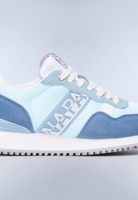 Jasnoniebieski i biały sneaker z zamszowymi akcentami, białymi sznurowadłami oraz logo "NAPAPIJRI" po boku i na języku, pokazany zbliżonym widokiem bocznym.