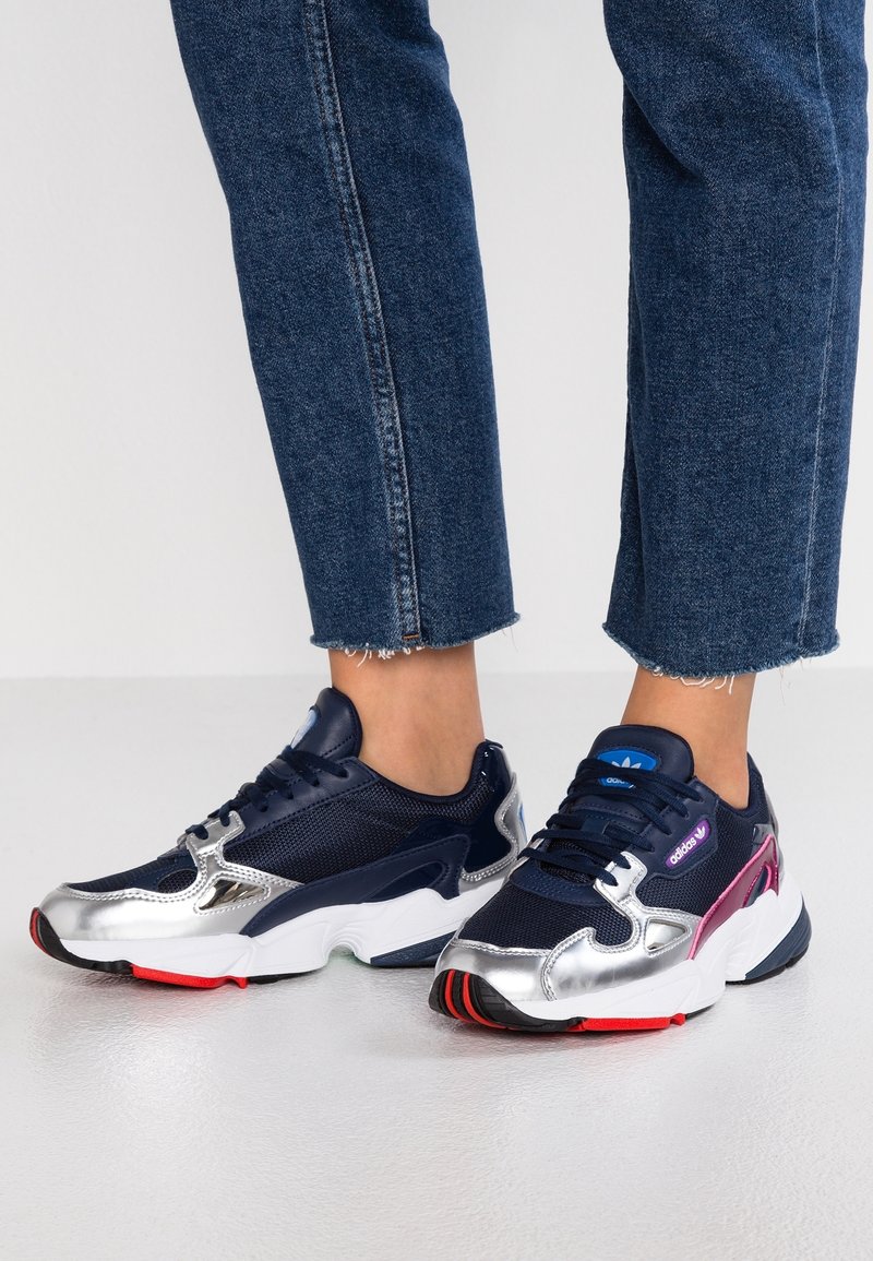 Marinblå mesh- och silvriga syntetiska sneakers med rosa och blå detaljer, med en kraftig sula och framträdande varumärke på plösen.