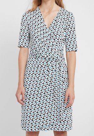 Korte ærmer omslagskjole i et sort, hvidt og blåt mønster. Har en v-hals, blød tekstur og et bånd i taljen.