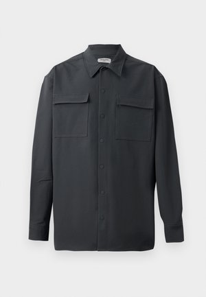 Tamsiai pilkas marškiniai su klasikiniais apykaklėmis, dviem priekinėmis kišenėmis ir kontrastingomis siūlėmis. Pagaminti iš lygaus, lengvo audinio.