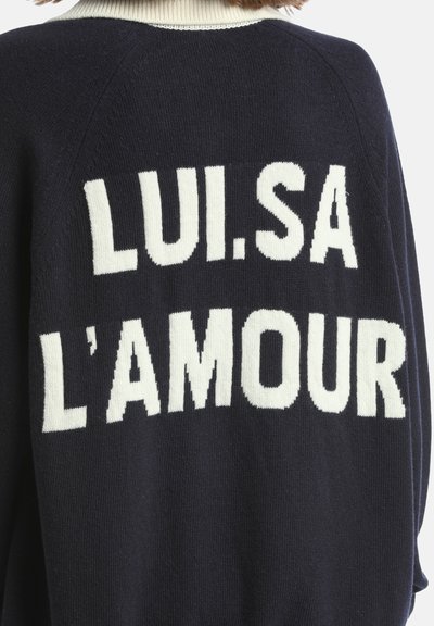 Oversized námorní sveter s textúrovaným pletením, ktorý má na chrbte veľké biele písmená "LUI.SA L'AMOUR" a kontrastný krémový golier.