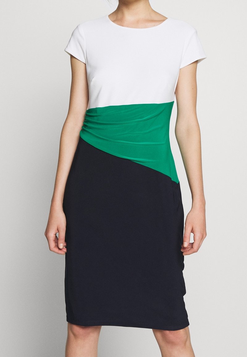 Knelång klänning med en vit överdel, grön midja med rynkdetaljer och en marinblå kjol. Tillverkad av stretchigt tyg.