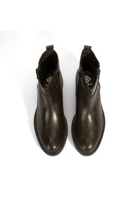 Bottines en cuir marron avec une finition lisse, dotées de fermetures éclairs sur le côté, d'un bout arrondi et d'un petit talon en caoutchouc pour la stabilité.