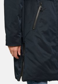 Donkerblauwe geïsoleerde jas met een gladde textuur, voorzien van een voorzak met rits en een zijritsdetail.