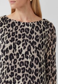 Blouse met luipaardprint en geplooid ontwerp, voorzien van een brede halslijn en lange mouwen. De stof is glad met een zachte, gestructureerde afwerking.