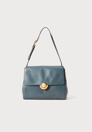 Leather handbag in dark blue with a structured design, featuring a gold circular clasp and a detachable strap for versatility.