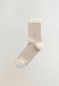 Șosetă cu dungi în culori crem și maro deschis, având o margine cu elastic, textură moale și secțiuni întărite la deget și călcâi.