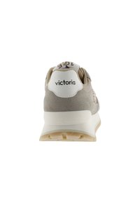Zapatilla beige y blanca con detalles brillantes, suela blanca gruesa y la marca "victoria" en la etiqueta del talón blanco, mostrada desde atrás.