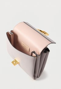 Leather handbag in grey and blush, featuring a structured shape, golden hardware, and a smooth interior. Three compartments inside.