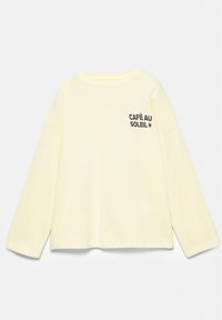 Sweat-shirt jaune pâle à manches longues avec texte noir "CAFÉ AU SOLEIL" et motif étoile sur la poitrine gauche sur fond blanc.