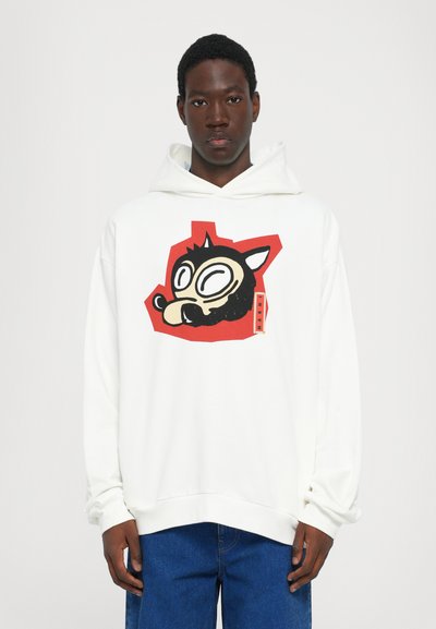 Weißer Hoodie mit großem, buntem Grafikdesign eines stilisierten schwarzen Tiergesichts, umrandet in Rot. Hat eine großzügige Passform und gerippte Bündchen.