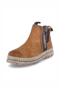 Bottine en nubuck marron avec un bout arrondi, fermeture éclair sur le côté et semelle en caoutchouc texturé dotée de rainures horizontales. Nom de la marque affiché sur la fermeture éclair.