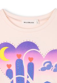 Jasnoróżowa bawełniana koszulka z nadrukiem serca i kaktusa w odcieniach purpury i niebieskiego, z żółtymi akcentami w kształcie księżyca i ozdobami z cyrkonii.