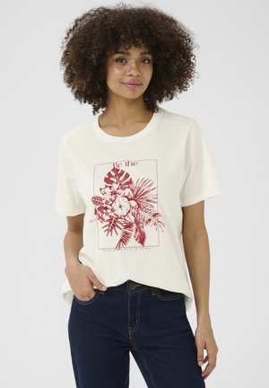 T-shirt couleur crème en coton, avec un design graphique floral rouge et du texte dans un cadre carré. Manches courtes, coupe décontractée.