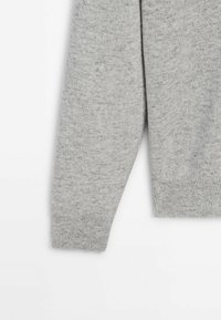 Grijze gebreide trui met lange mouwen, geribbelde manchetten en een zachte textuur. De stof heeft een subtiel gespikkeld patroon.