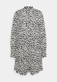 Svart och vit mönstrad klänning med krage, långa ärmar och rynkad midja. Tillverkad av lättviktig tyg med en flödande design.