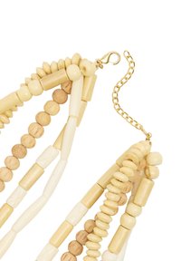 Naturalna drewniana naszyjnik z koralików, zawierający mieszankę jasnobeżowych i kremowych koralików, z zapięciem i przedłużką w kolorze złotym.