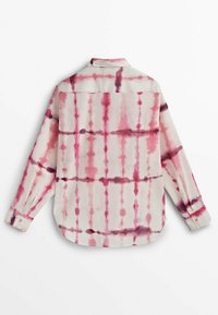 Chemise à manches longues avec col, rayures tie-dye verticales et horizontales rose et violettes sur fond blanc, vue de dos.
