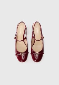 Pantofi slingback din piele lăcuită bordeaux, cu vârf rotund, curea la gleznă și detalii decorative cu cataramă în față.
