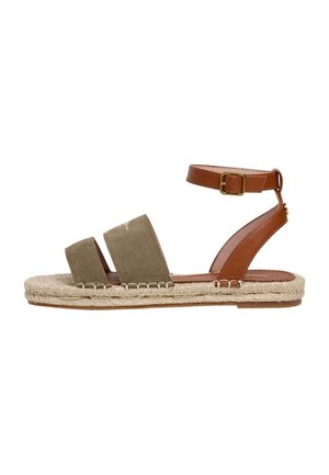 Flache Sandale mit beige geflochtener Sohle, zwei olivgrünen Wildlederriemen über den Zehen und einem braunen Knöchelriemen mit goldener Schnalle.