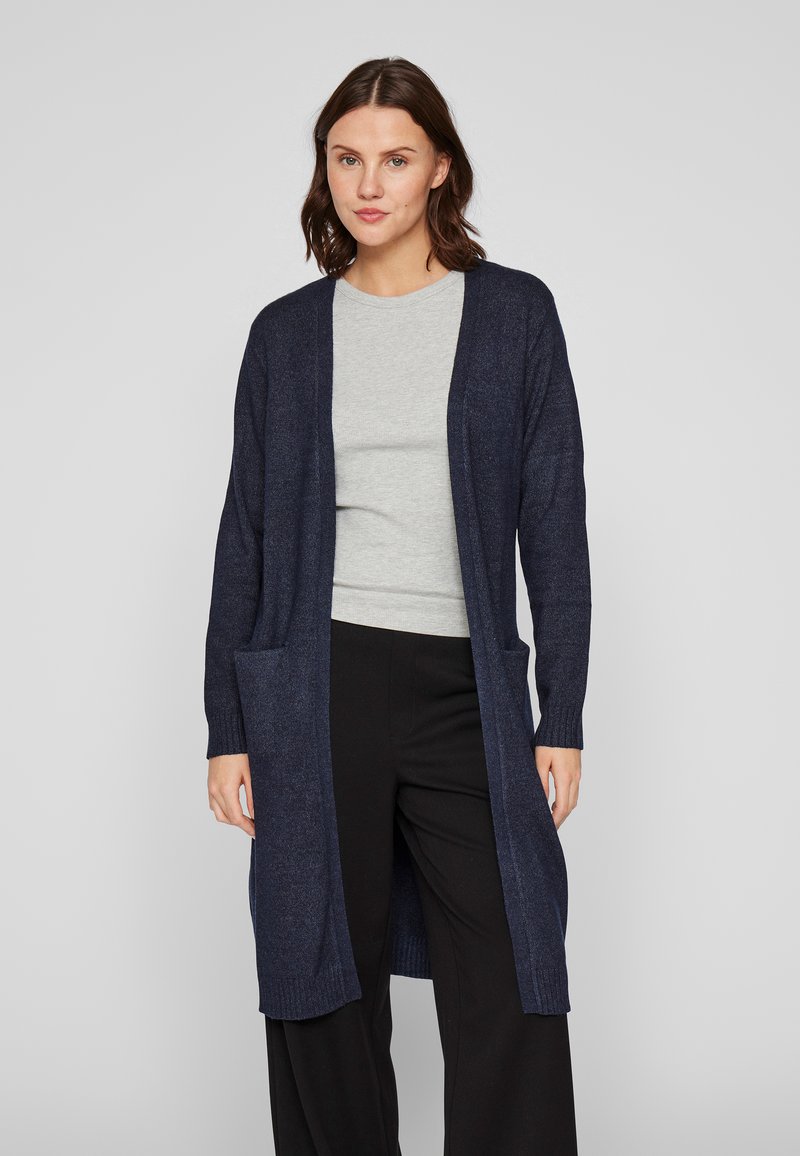 Μακρύ ναυτικό ζακέτα φτιαγμένο από μαλακό ύφασμα, με ανοιχτό μπροστινό μέρος, πλαϊνές τσέπες, ριχτές μανσέτες και χαλαρή σιλουέτα.