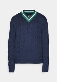 Pull bleu marine en maille torsadée avec col en V rayé vert et blanc et manches longues.